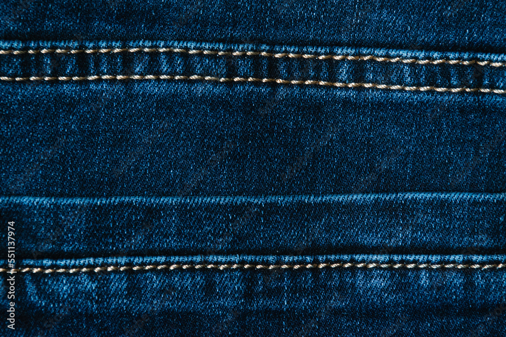 Blue denim fabric close up, denim background with copy space. Back pocket of jeans. Blue denim fabric close up, denim background with copy space. Back pocket of jeans.