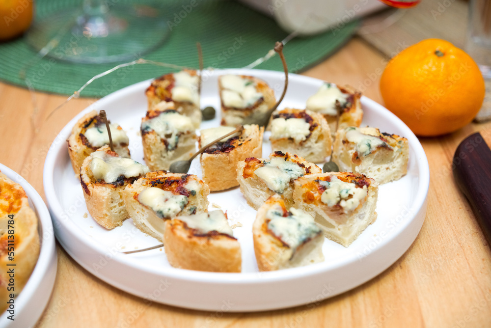 A plate of sliced tartlets with gorgonzola (edible moldy cheese). Bite size portions. A plate of sliced tartlets with gorgonzola (edible moldy cheese). Bite size portions.