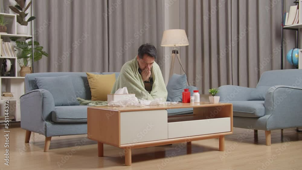 Asian Man With Blanket Trying To Get Warm On Sofa In The Living Room At Home
Asian Man With Blanket Trying To Get Warm On Sofa In The Living Room At Home