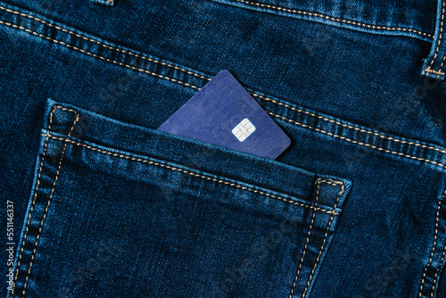 A bank card in the back pocket of dark blue jeans. The concept of purchases on credit