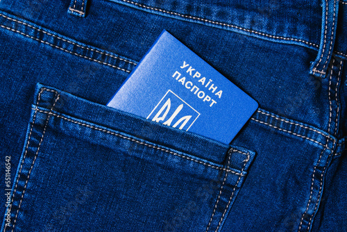 Foreign passport of a citizen of Ukraine in the pocket of jeans. Concept of refugees during war. photo