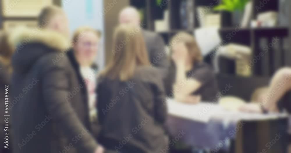 silhouettes of a company of unrecognizable young people working in a coworking space.blurry defocused business topic video.