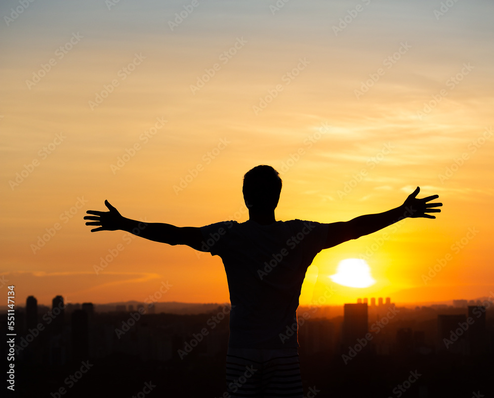 Man with open arms to the sunset in Sao Paulo, Brazil
