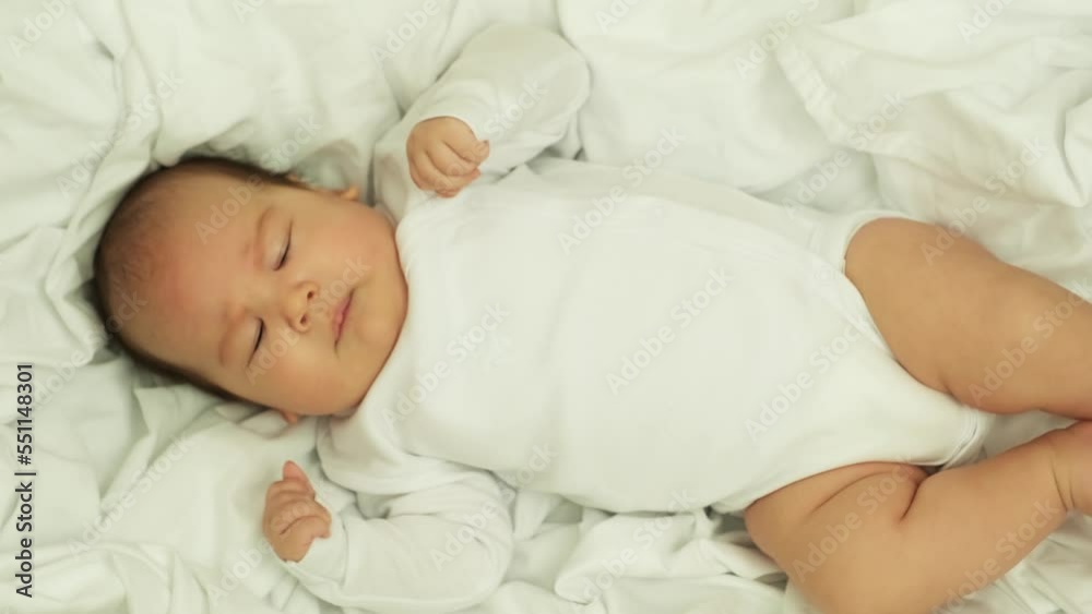 newborn baby smiles and laughs. shows emotions. baby lies on a white cloth newborn baby smiles and laughs. shows emotions. baby lies on a white cloth