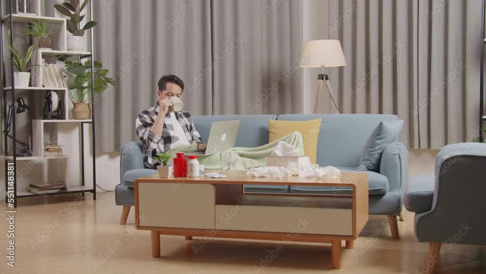 Sickasian Man With Blanket Drinking Hot Water While Lying On Sofa Works On A Laptop Computer In The Living Room At Home
Sickasian Man With Blanket Drinking Hot Water While Lying On Sofa Works On A Laptop Computer In The Living Room At Home