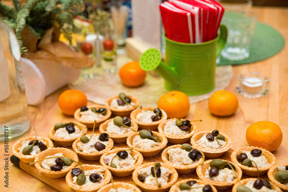 Tartlets filled with pate and garnished with olive and large capers