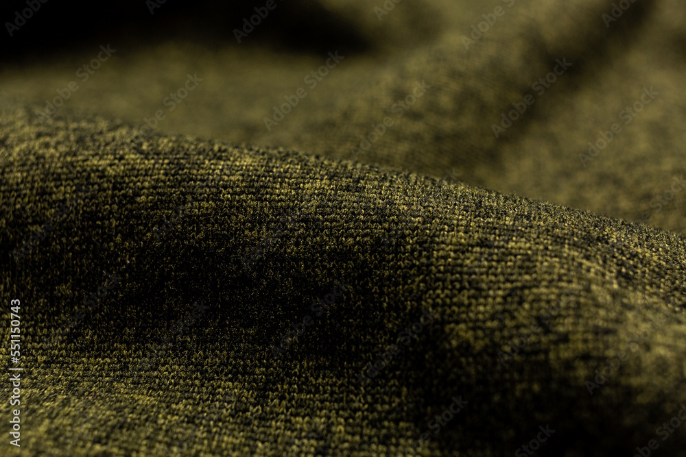 Closeup texture of knitted fabric in green color. Light khaki back.