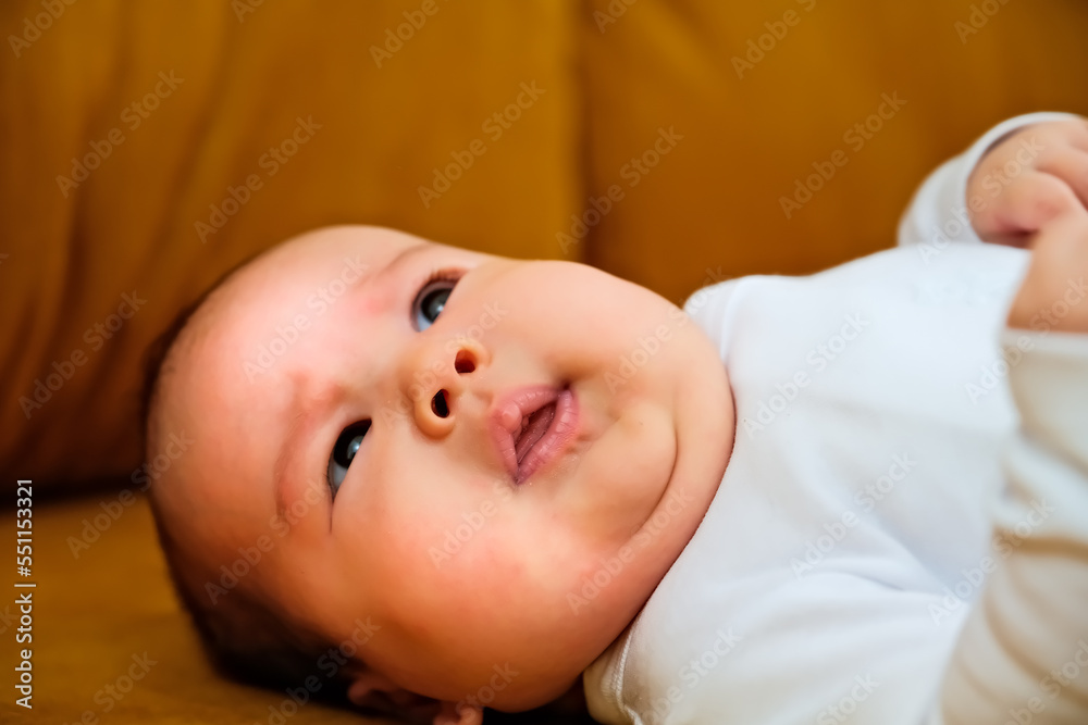 newborn baby lies on the dewan. newborn baby shows different emotions