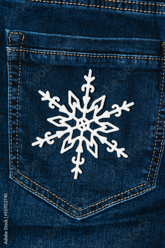 Christmas snowflake decoration on a dark denim background. Concept of preparation for the holiday