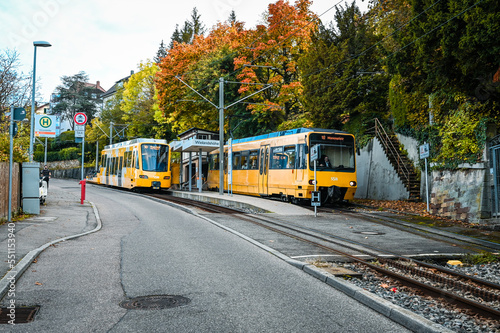 Stuttgart, Germany: October 16, 2022: Two yellow cog railway cars standing at a station during autumn.