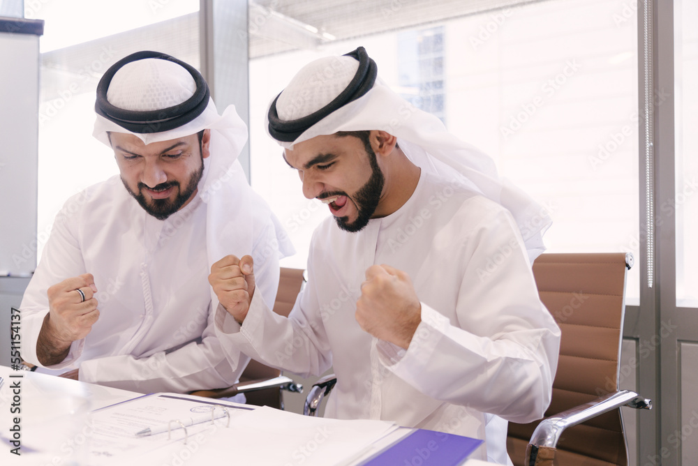 wo middle eastern businessmen wearing traditional emirates kandora working in the office wo middle eastern businessmen wearing traditional emirates kandora working in the office