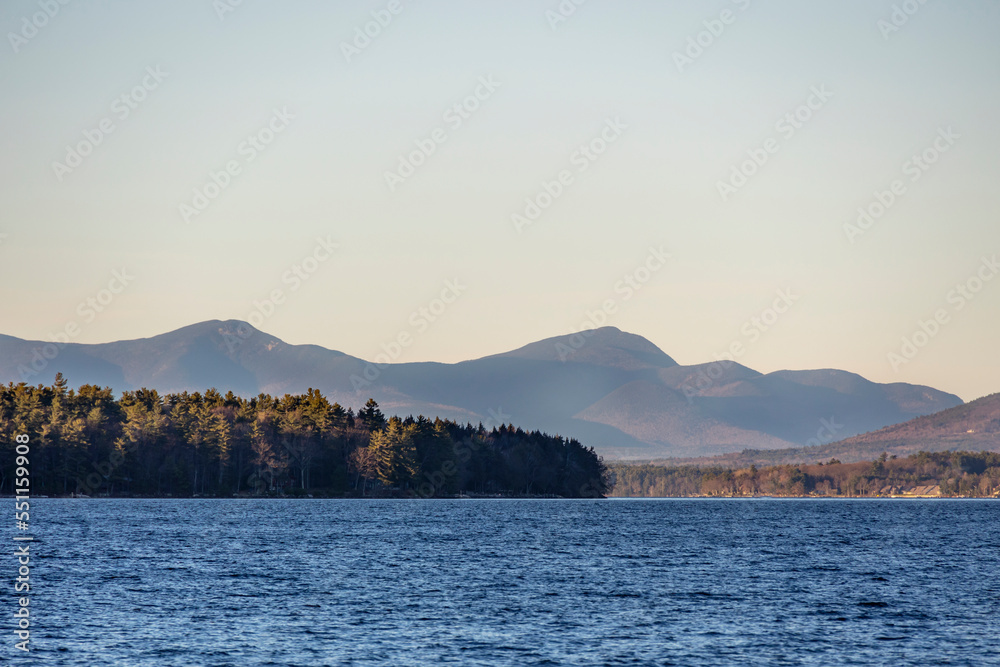 Mountain peaks in the distance behind a lake in the fall