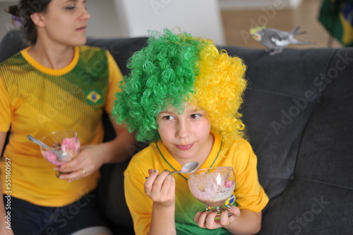 mãe e filha assistindo jogo do brasil copa do mundo pela tv em casa cores lindas 