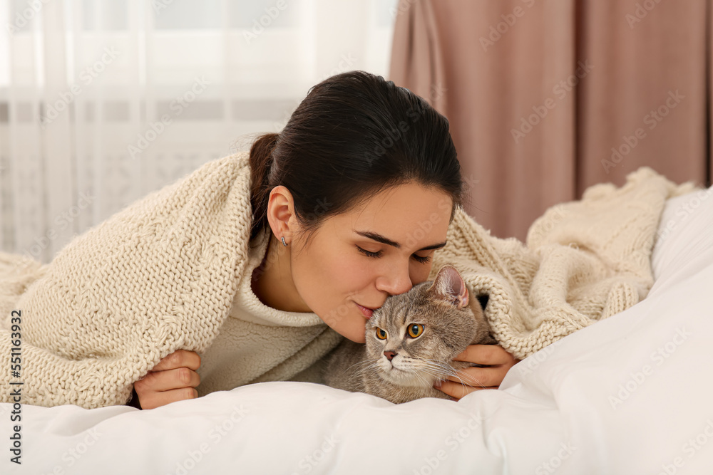 Young woman kissing her adorable cat at home Young woman kissing her adorable cat at home