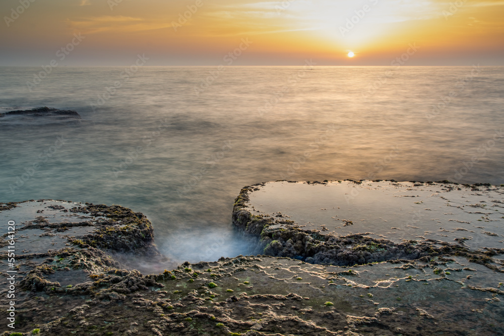 Fototapeta premium Landscape, sunset in the landscape of the Mediterranean Sea, Israel. Long exposure of waves, dramatic, detailed sky, algae, rocks