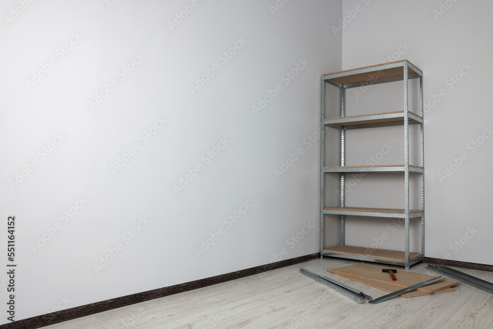 Office room with white walls and metal storage shelf. Space for text Office room with white walls and metal storage shelf. Space for text
