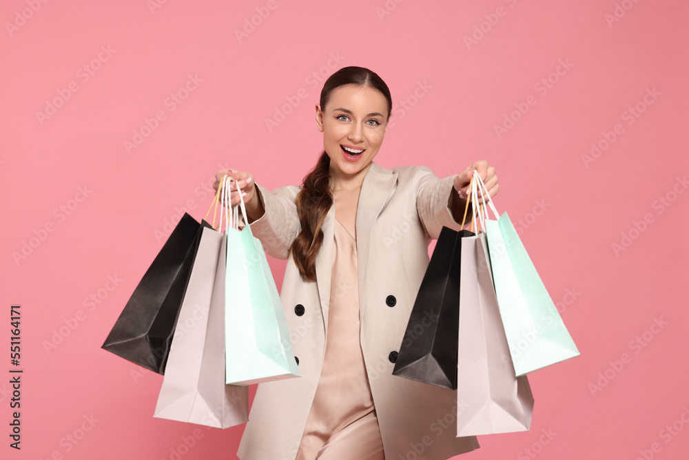 Stylish young woman with shopping bags on pink background Stylish young woman with shopping bags on pink background