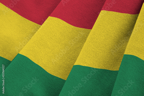 Bolivia flag with big folds waving close up under the studio light indoors. The official symbols and colors in fabric banner photo