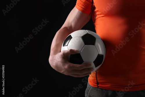 Athletic man with soccer ball on black background  closeup. Space for text