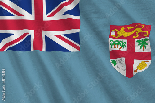 Fiji flag with big folds waving close up under the studio light indoors. The official symbols and colors in fabric banner photo