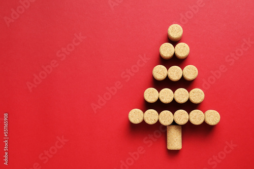 Christmas tree made of wine corks on red background, top view. Space for text