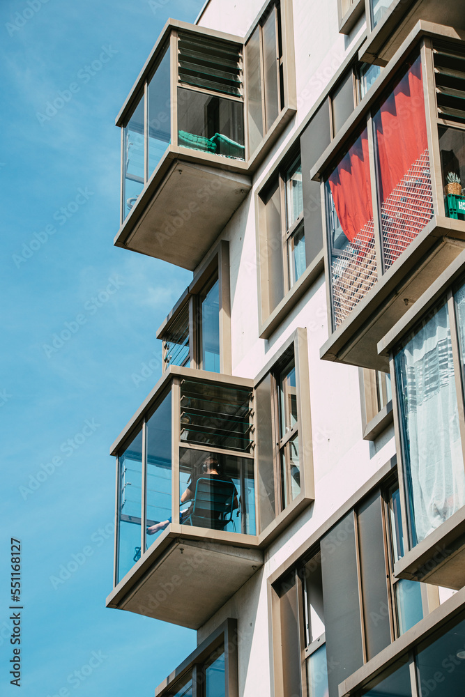Young man listening to music on an original balcony of a modern and innovative new building in Nantes, France