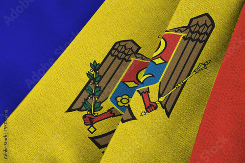 Moldova flag with big folds waving close up under the studio light indoors. The official symbols and colors in fabric banner