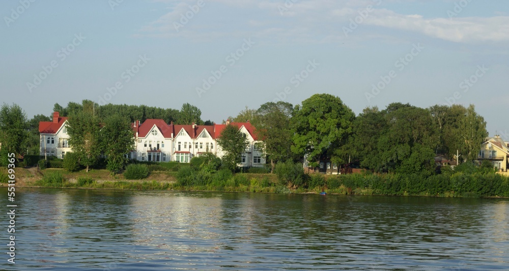 Beautiful house with a red roof and a white facade on the banks of the Volga River.