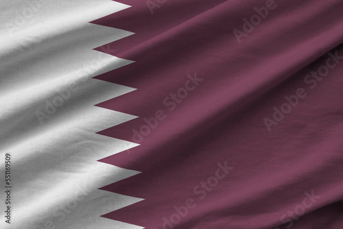 Qatar flag with big folds waving close up under the studio light indoors. The official symbols and colors in fabric banner photo