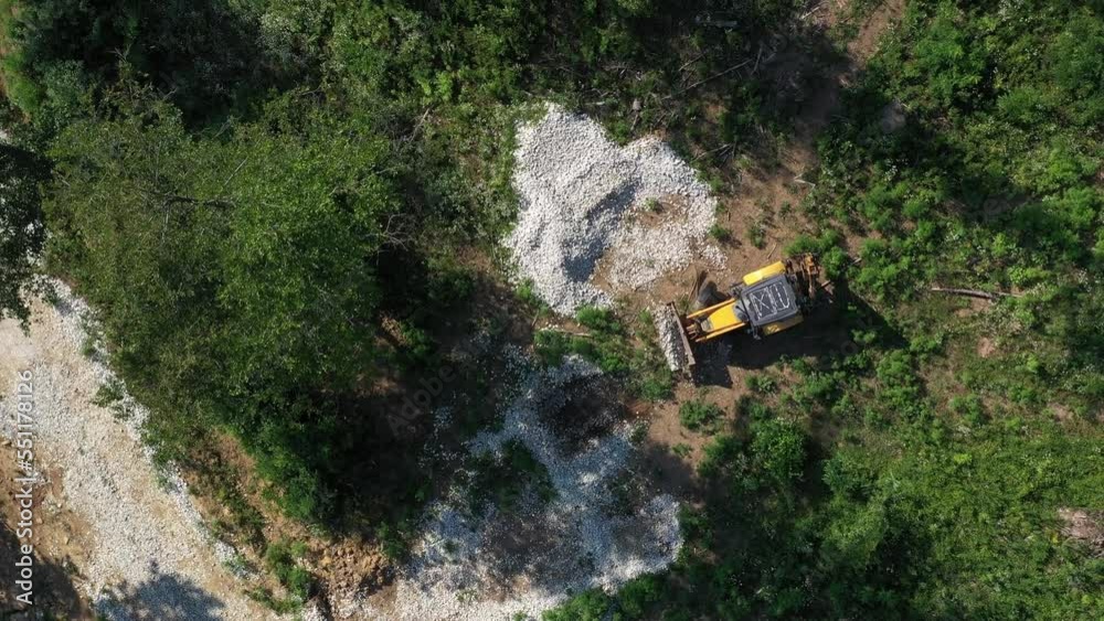 A modern tractor on a construction site from the air. A yellow wheel loader lifts and moves garbage. Heavy machinery is working at the facility. A modern tractor on a construction site from the air. A yellow wheel loader lifts and moves garbage. Heavy machinery is working at the facility.