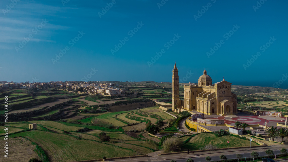 Drone panorama or majestic and big Basilica of the National Shrine of the Blessed Virgin of Ta' Pinu on the island of Gozo, Malta on a sunny day.