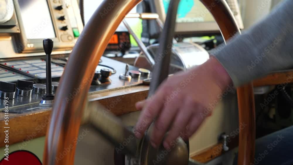 Hand turns big old wooden steering wheel on boat. Hand turns big old wooden steering wheel on boat.