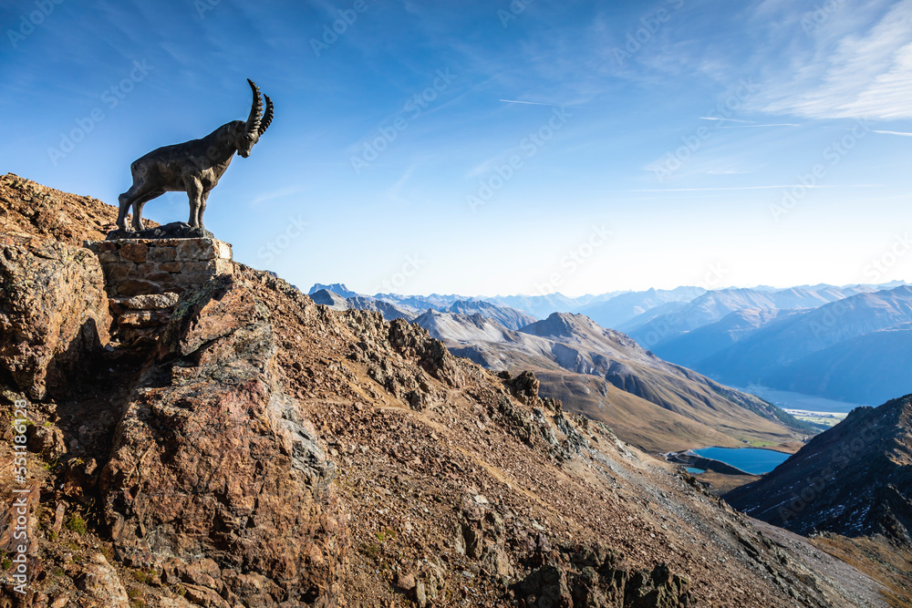 Ibex above Piz Nair mountain range with lake in the Alps, Engadine, Switzerland