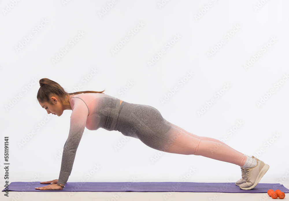 young woman doing fitness exercises on a white background isolated.sports exercises for body shaping young woman doing fitness exercises on a white background isolated.sports exercises for body shaping