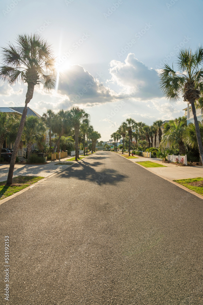 Sun behind the clouds above the asphalt street in a residential area at Destin, Florida Sun behind the clouds above the asphalt street in a residential area at Destin, Florida