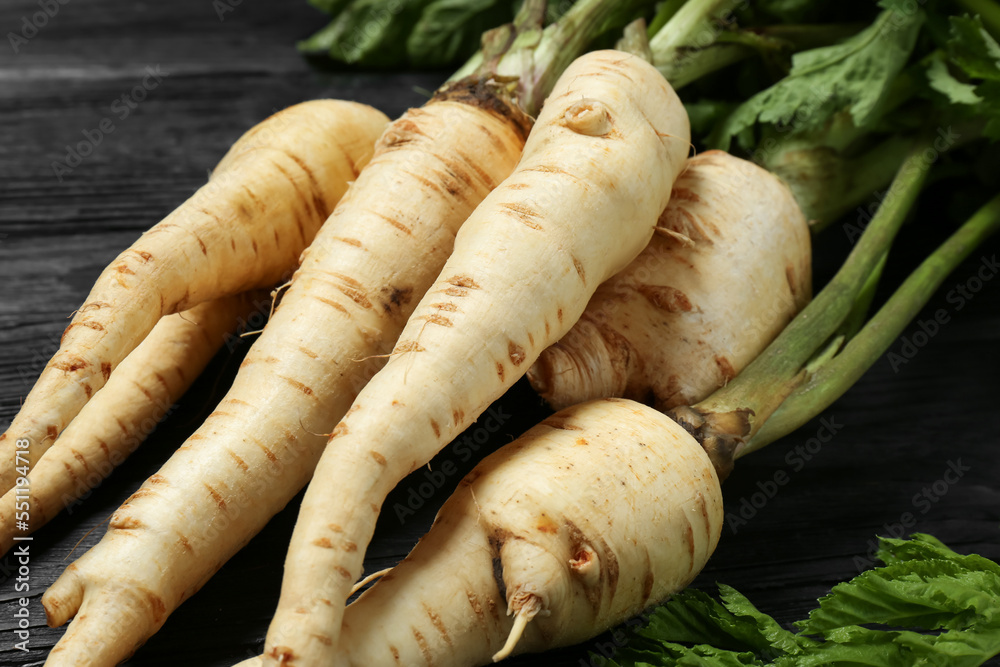 Tasty fresh ripe parsnips on black wooden table, closeup Tasty fresh ripe parsnips on black wooden table, closeup