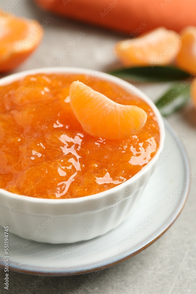 Delicious tangerine jam on light grey table, closeup Delicious tangerine jam on light grey table, closeup