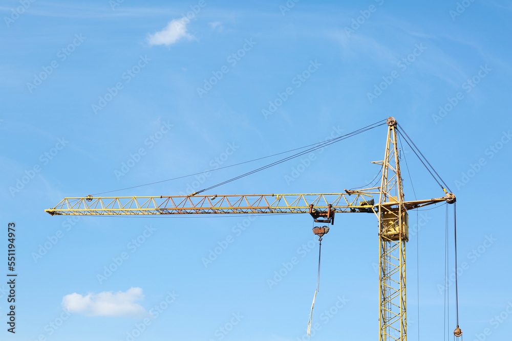 Modern tower crane against blue sky. Construction site