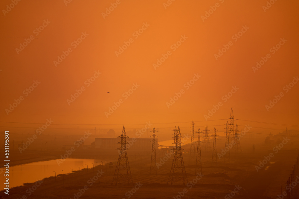 Fototapeta premium High voltage power lines and transmission towers at golden sunset. Industry energy supply concept