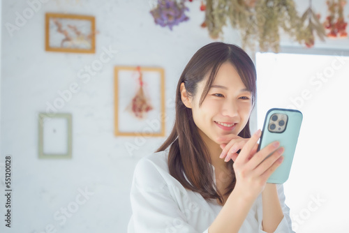 スマホを見て笑顔になる女性