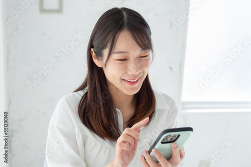 スマホをタップする若い女性