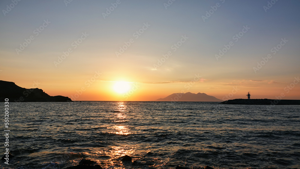 Samothrace island from Gökçeada- Imbros Island at sunset, with lightroom, mountain, sky. Aegean sea sunset view across to the Semadirek, Samothace island