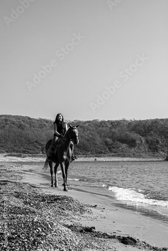 Girl and horse. Horse riding by the sea.