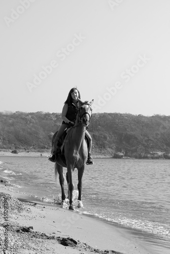 Girl and horse. Horse riding by the sea.