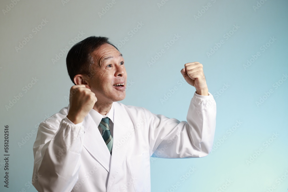 Middle-aged Asian doctor in a white coat on blue background. Concept image of regenerative medicine, vaccine development and advanced therapy.