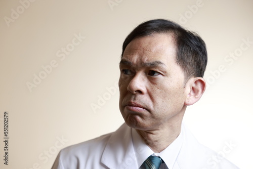 Middle-aged Asian doctor in a white coat on white background. Concept image of regenerative medicine, vaccine development and advanced therapy.