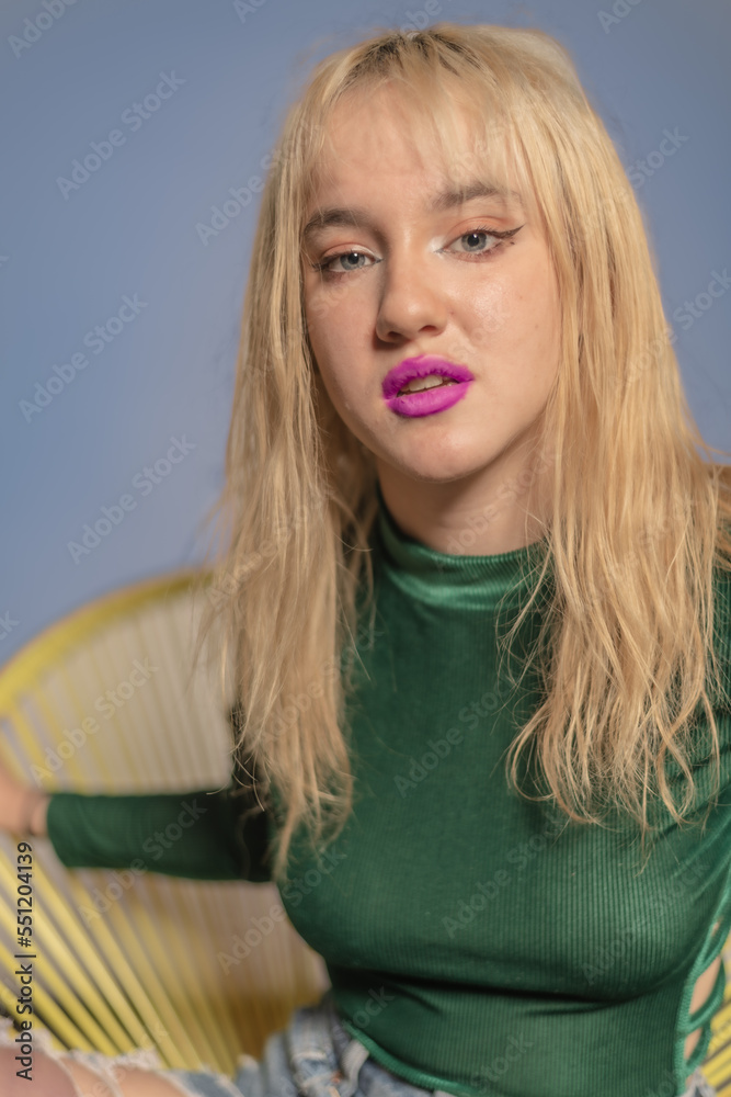 Young blond LA citizen poses in studio wearing a green leotard and jeans. Young blond LA citizen poses in studio wearing a green leotard and jeans.