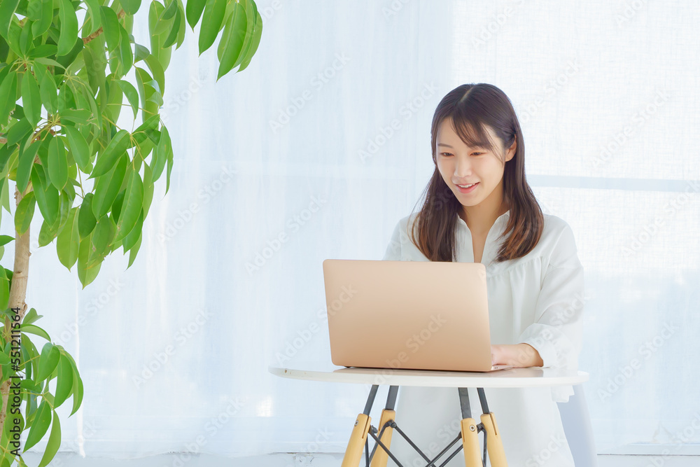 笑ってパソコンを操作する女性 笑ってパソコンを操作する女性
