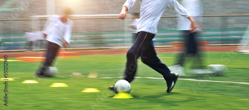 Low section of young boys playing soccer game with blurred motion
