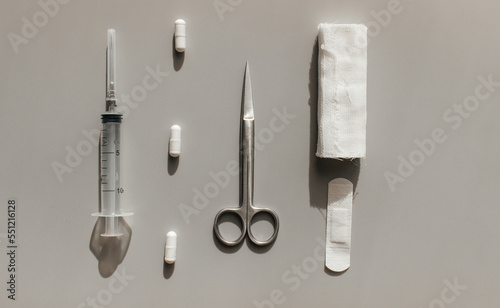 Tools to help the patient. For dressing the wound - scissors, bandages, adhesive plaster. For anesthesia syringes and tablets. View from above.